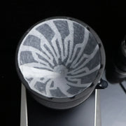 The Hario Alpha coffee dripper in matte black, featuring a minimalist cone-shaped design for manual pour-over brewing.