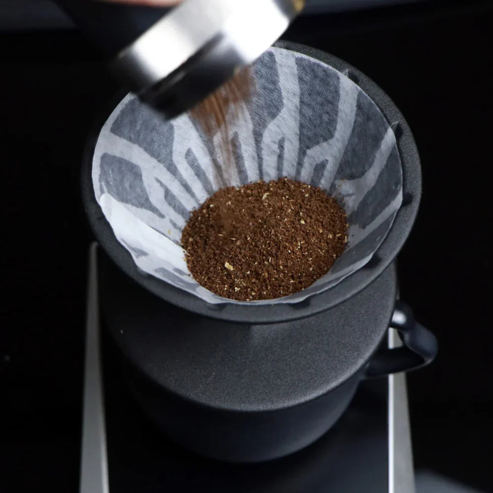 The Hario Alpha coffee dripper in matte black, featuring a minimalist cone-shaped design for manual pour-over brewing.