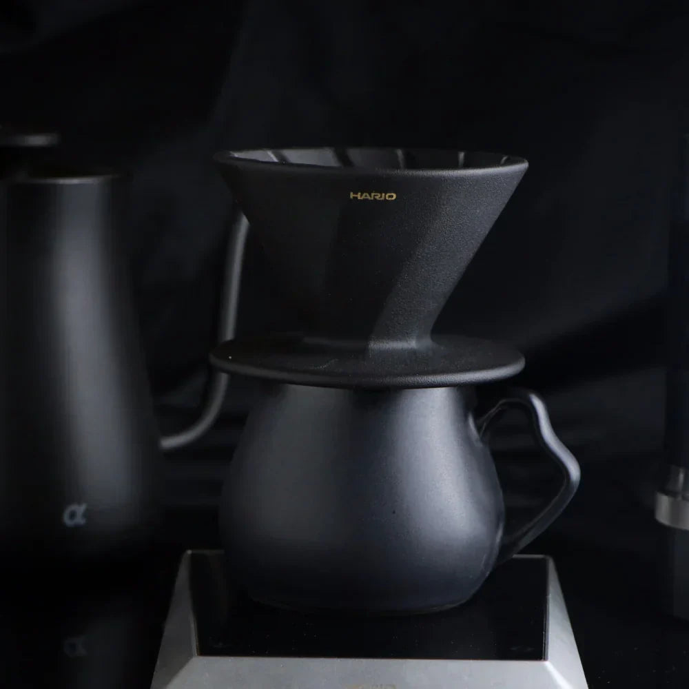 The Hario Alpha coffee dripper in matte black, featuring a minimalist cone-shaped design for manual pour-over brewing.