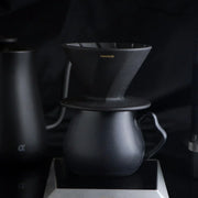 The Hario Alpha coffee dripper in matte black, featuring a minimalist cone-shaped design for manual pour-over brewing.