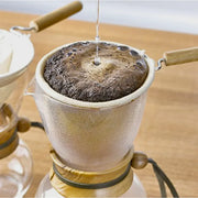 Hario Drip Pot with Olive Woodneck collar and reusable cloth filter for authentic Nel drip coffee brewing.
