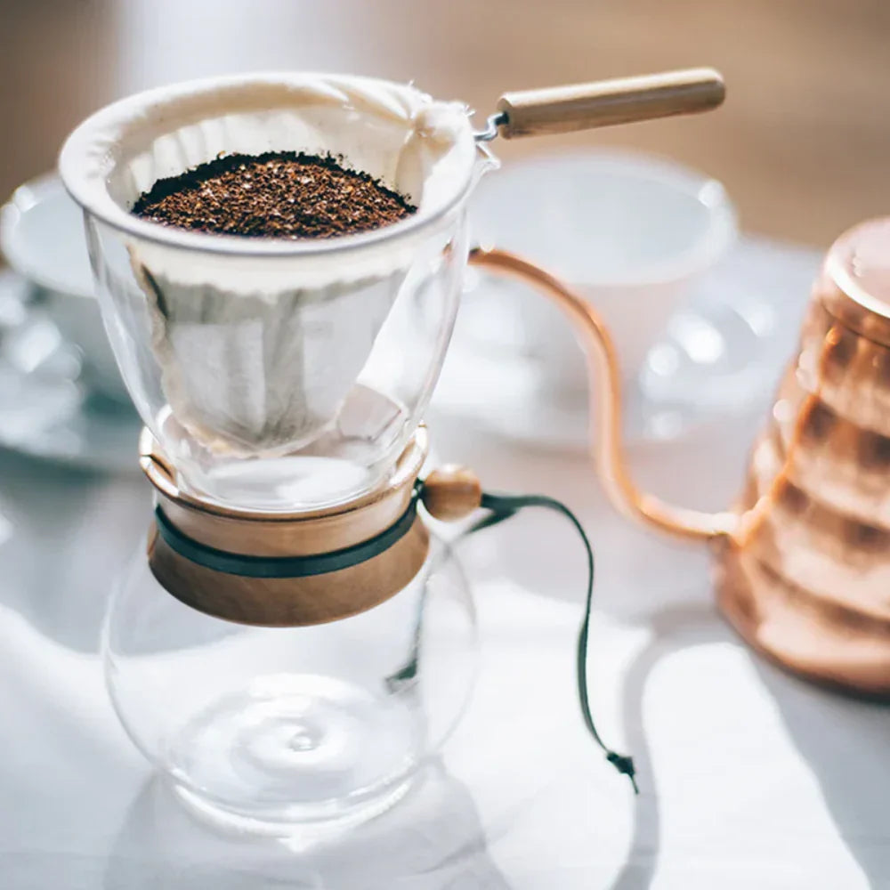 Hario Drip Pot with Olive Woodneck collar and reusable cloth filter for authentic Nel drip coffee brewing.