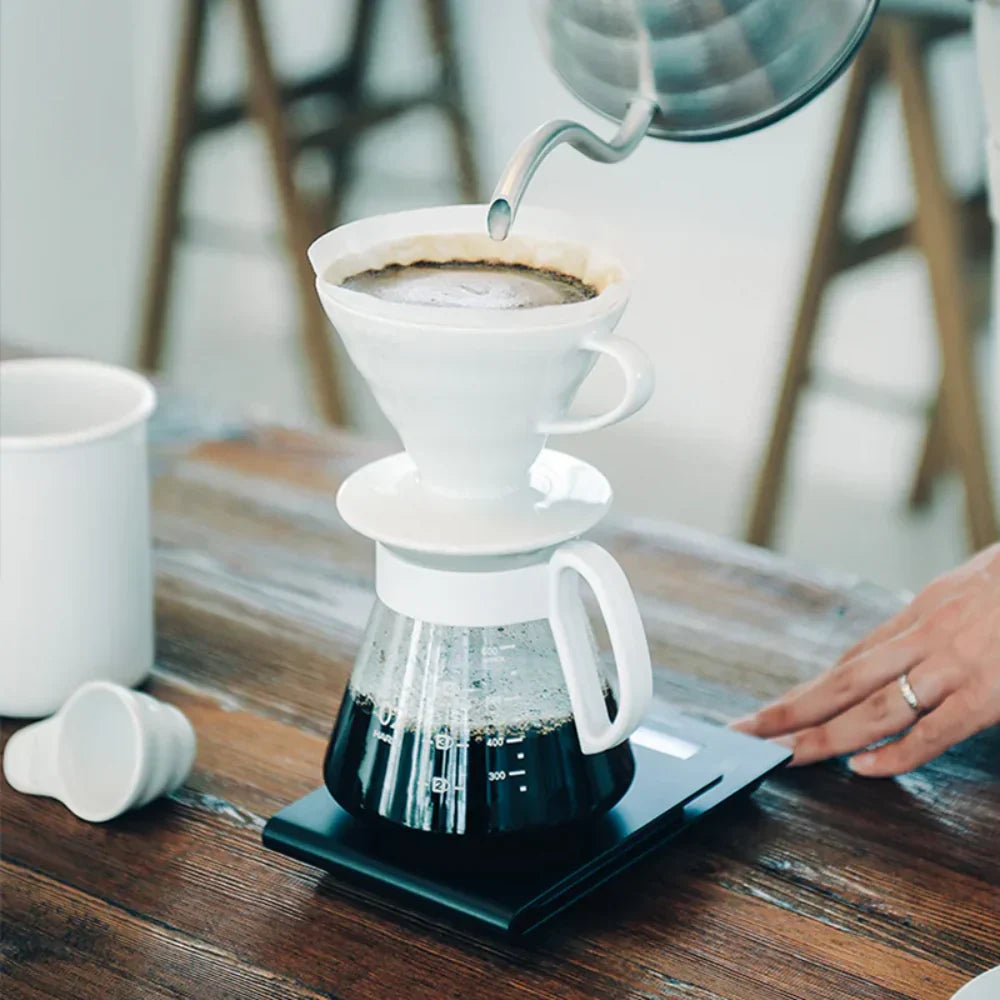 White ceramic Hario V60 pour-over set with a size 02 dripper for superior heat retention and a heatproof glass carafe.